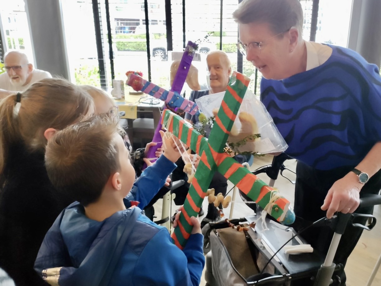 Leerlingen geven palmpaasstokken weg